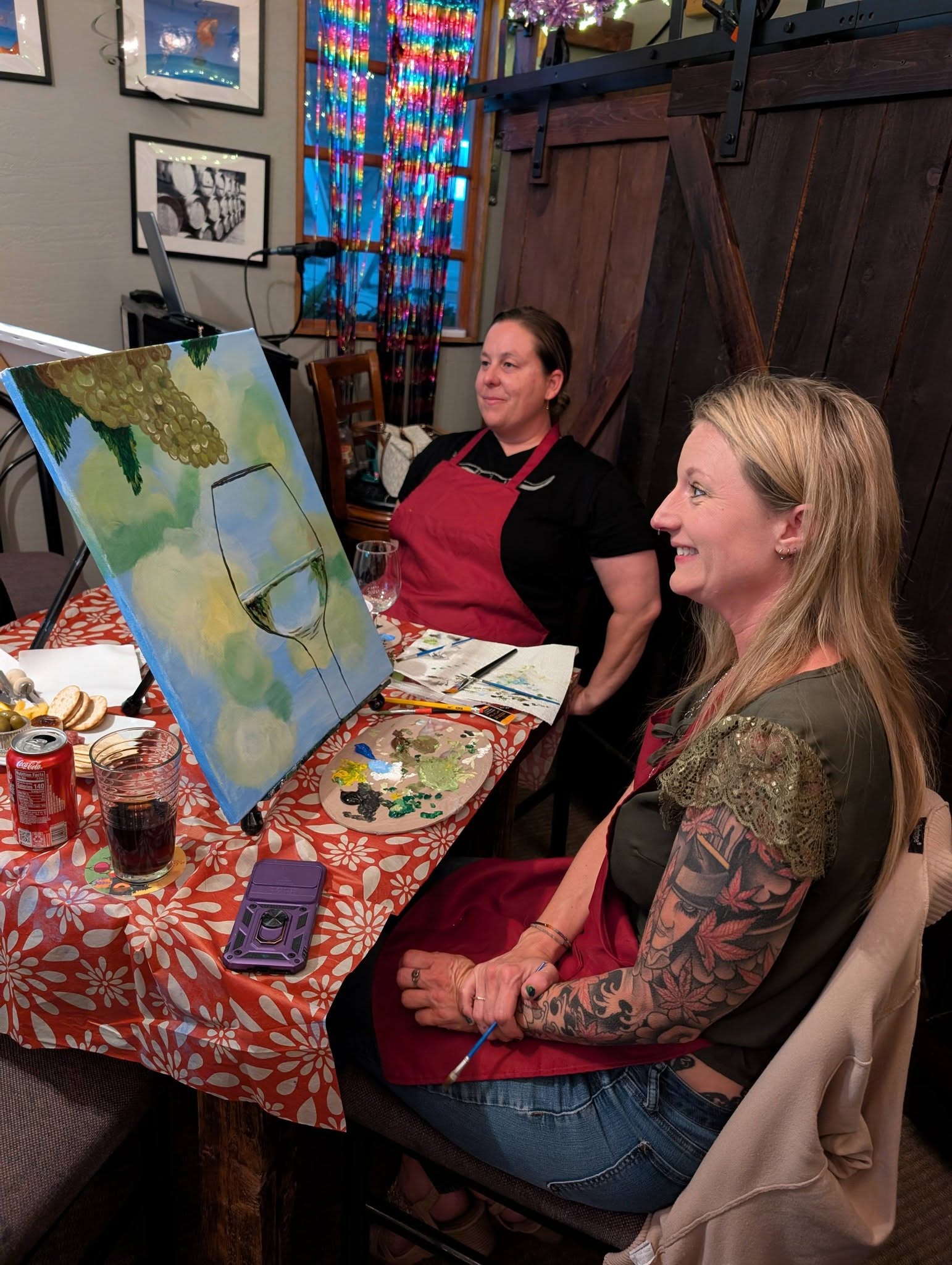 Two women painting together at a paint class