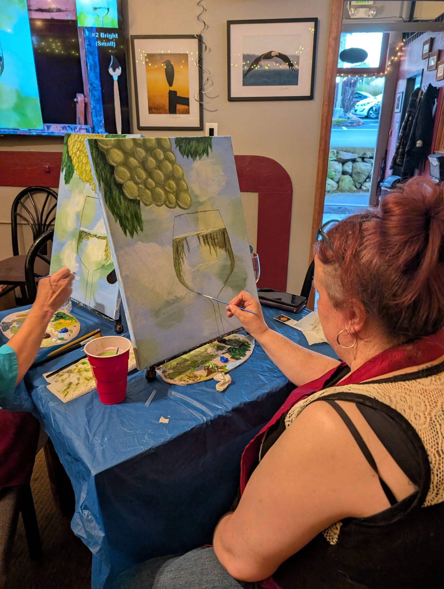 Guest working on a painting at a paint and sip table