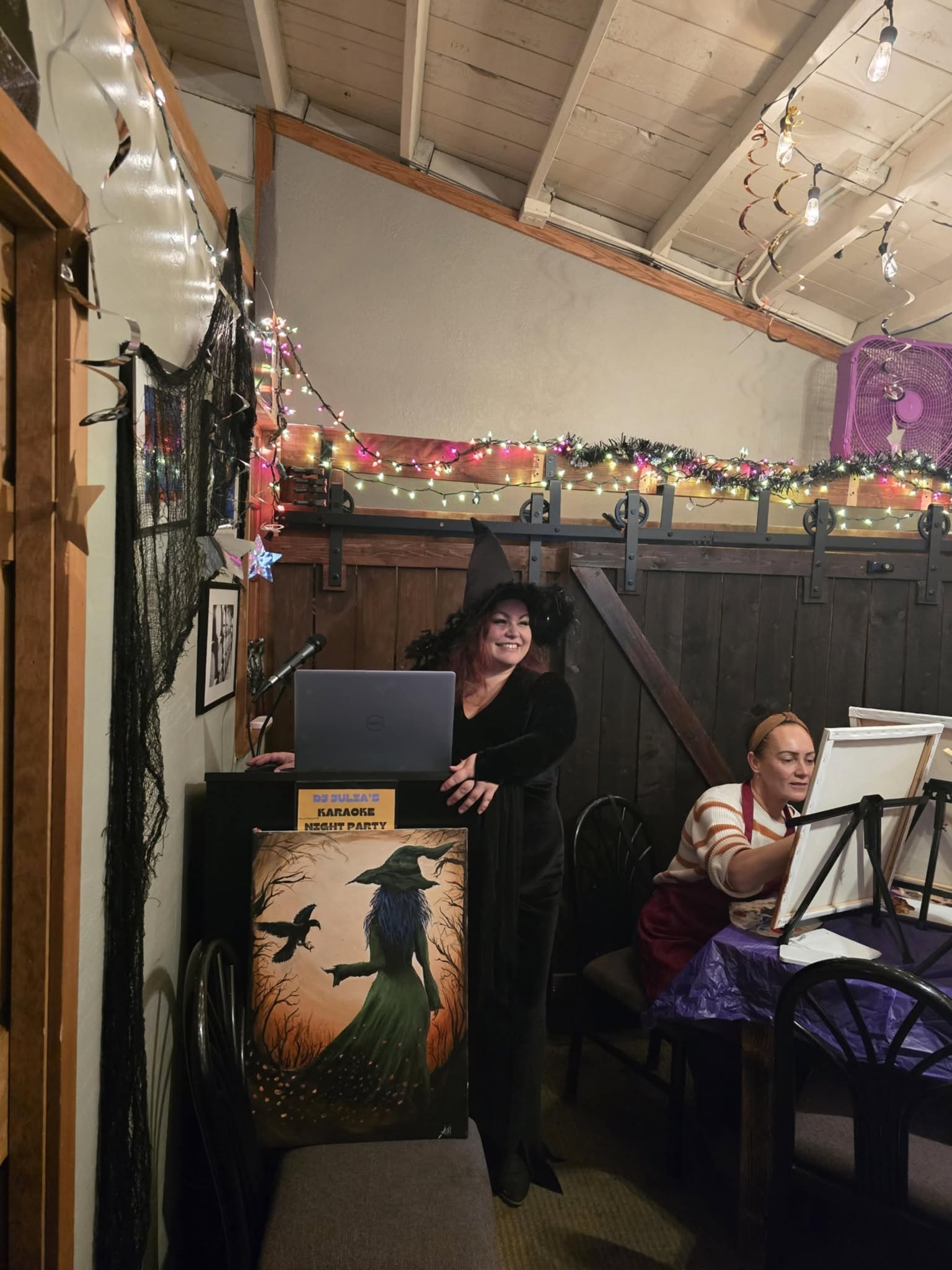 Paint class set up in a room lit with string lights