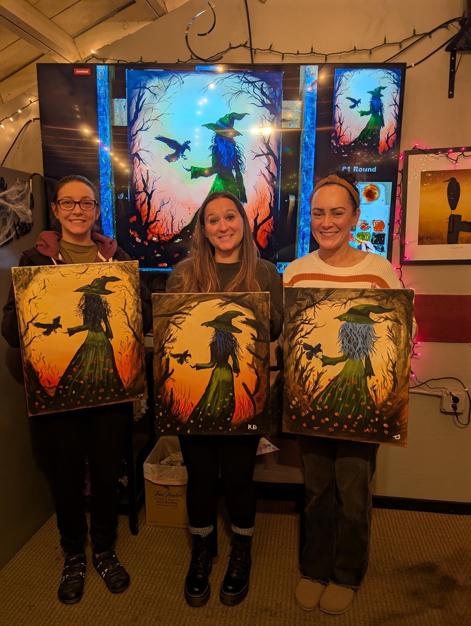 Group holding Halloween witch silhouette paintings