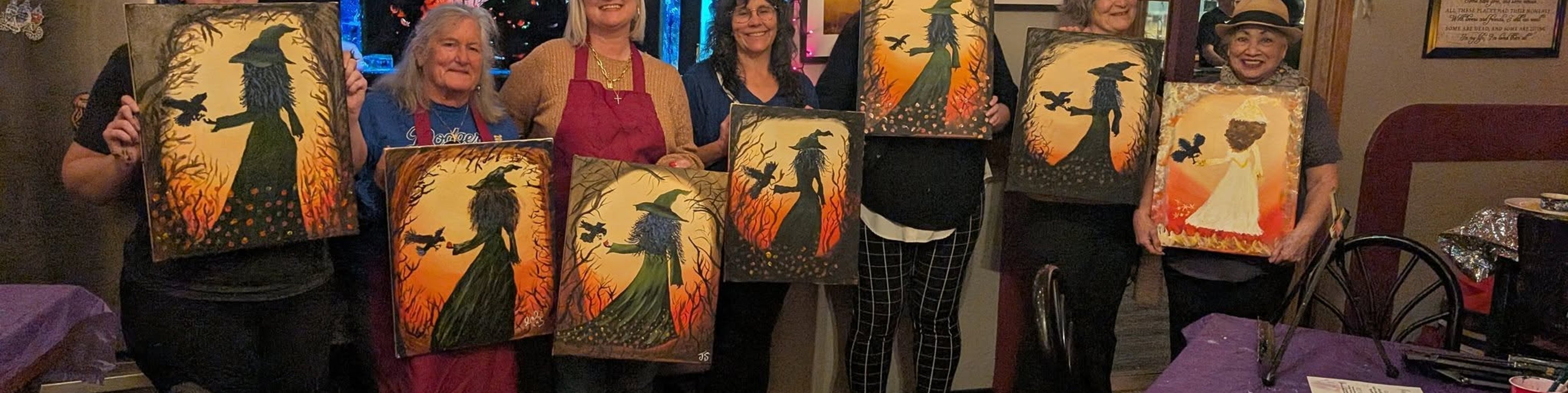 Paint night group lined up with Halloween paintings