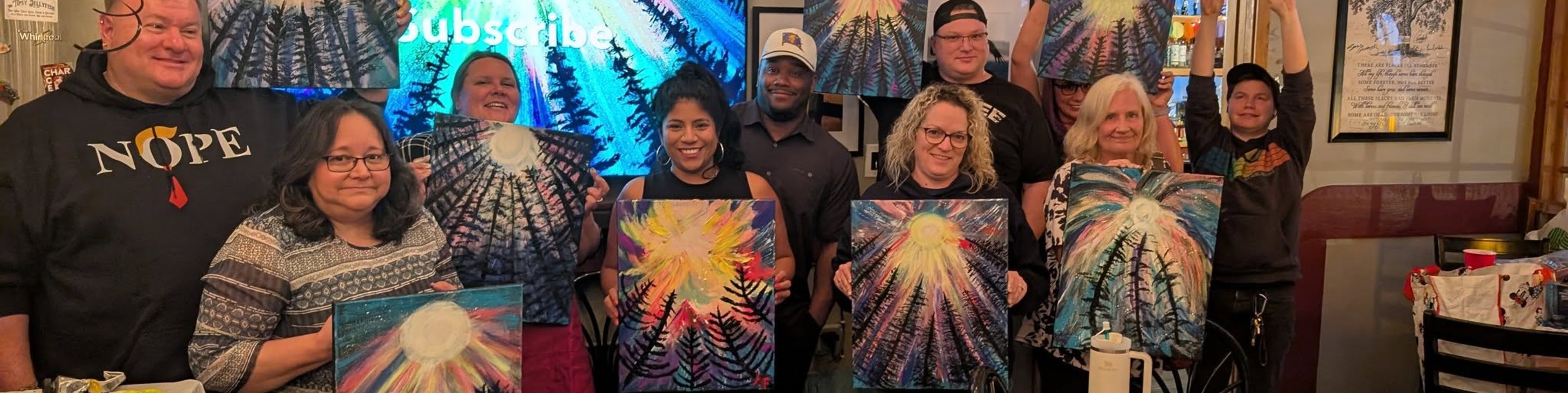 Packed paint night with guests holding their paintings