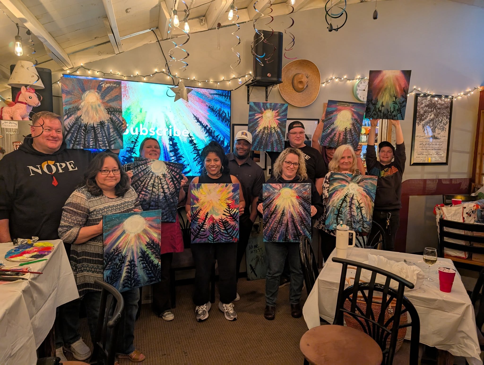 Packed paint night with guests holding their paintings