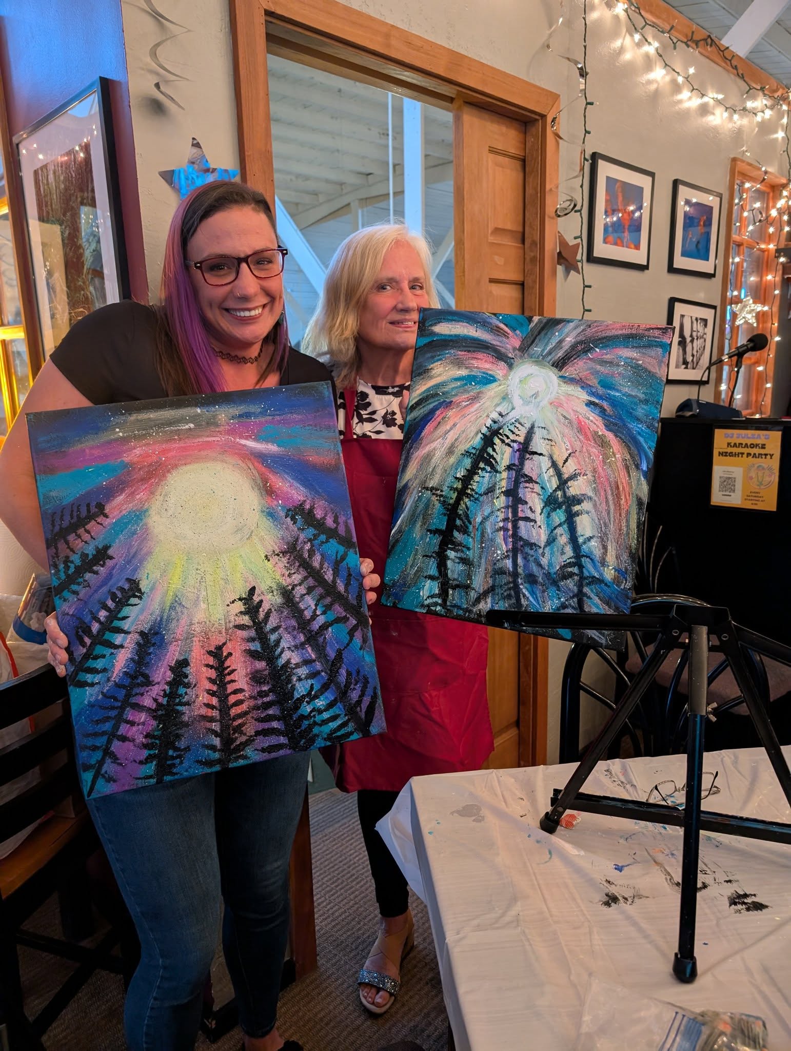Group holding sunburst paintings at a paint class