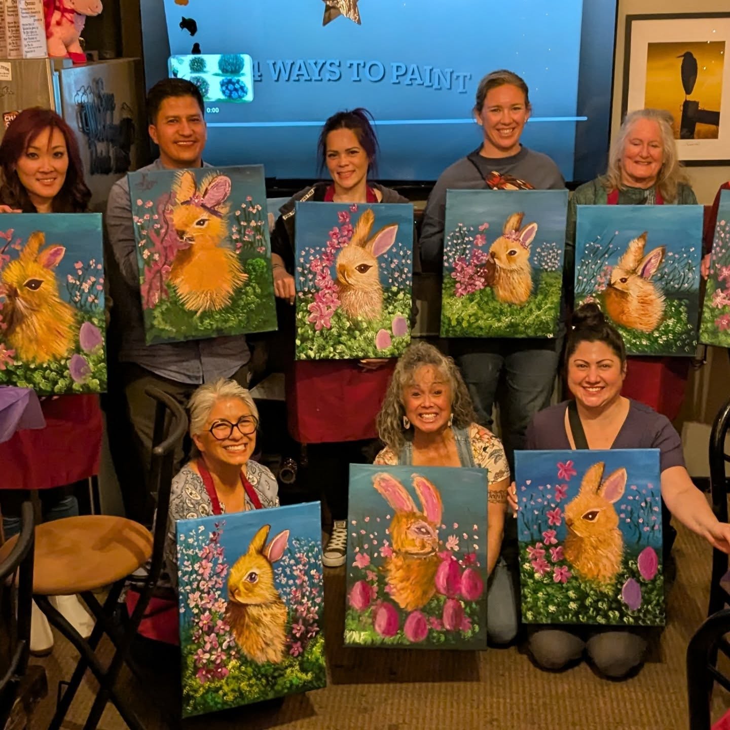 Paint class group showing off spring bunny paintings