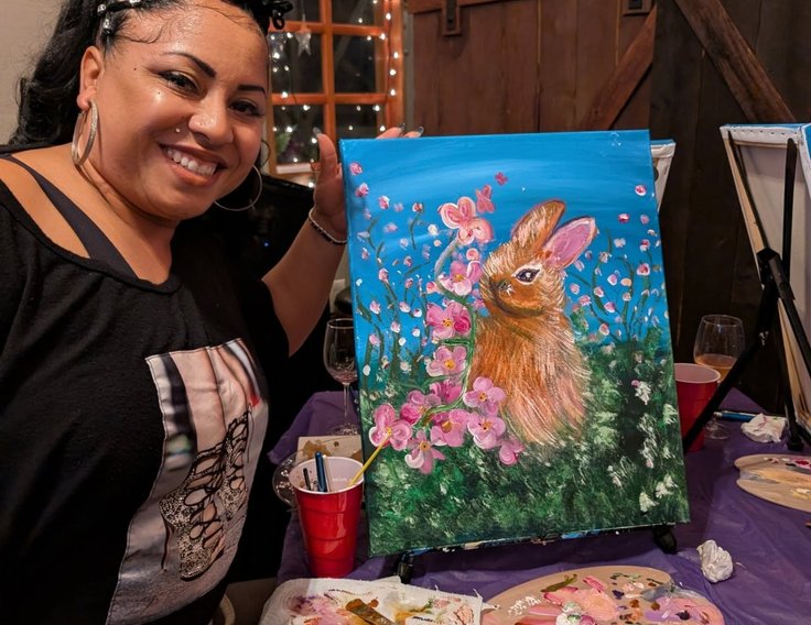 Guest smiling with her colorful bunny painting