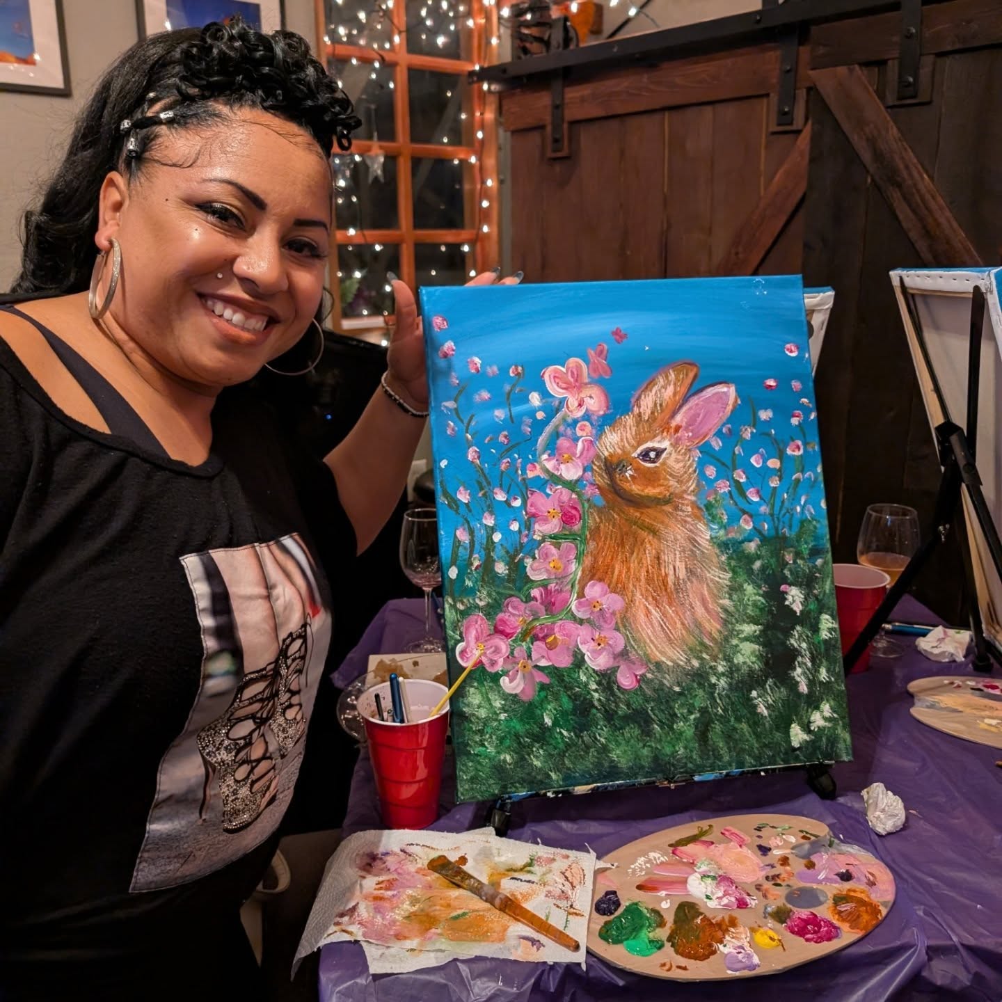 Guest smiling with her colorful bunny painting