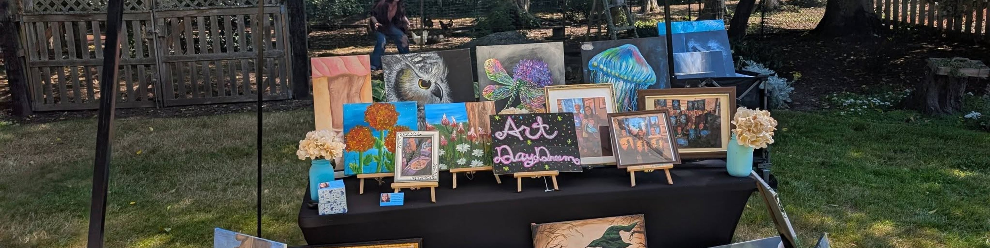 Art Day Dream canopy booth with paintings at an outdoor market