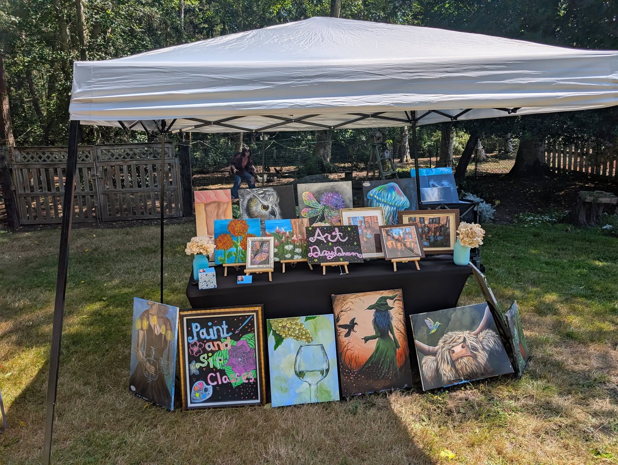 Art Day Dream canopy booth with paintings at an outdoor market