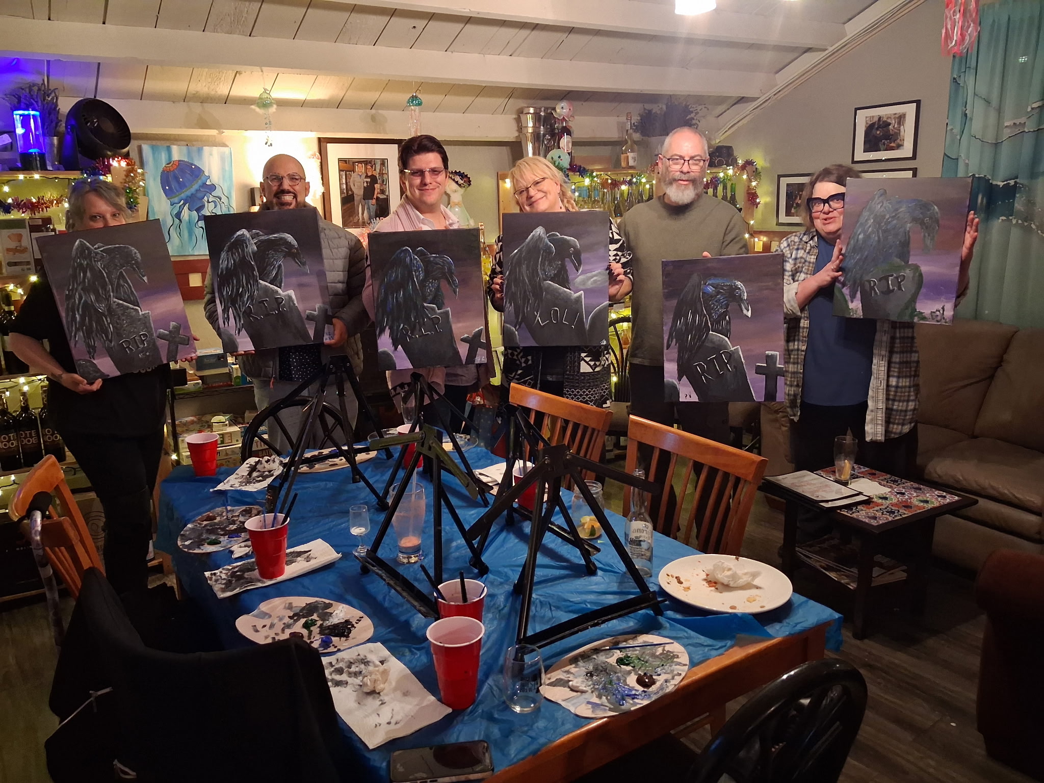 Paint night group lined up with Halloween paintings