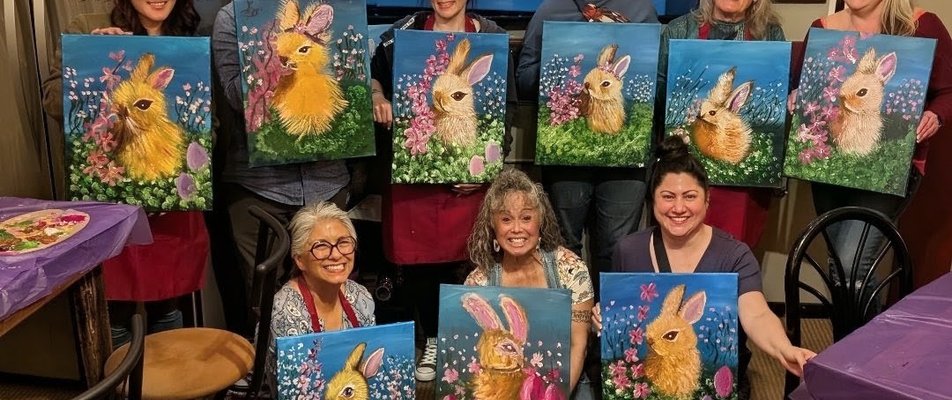 Large paint night group holding their finished paintings