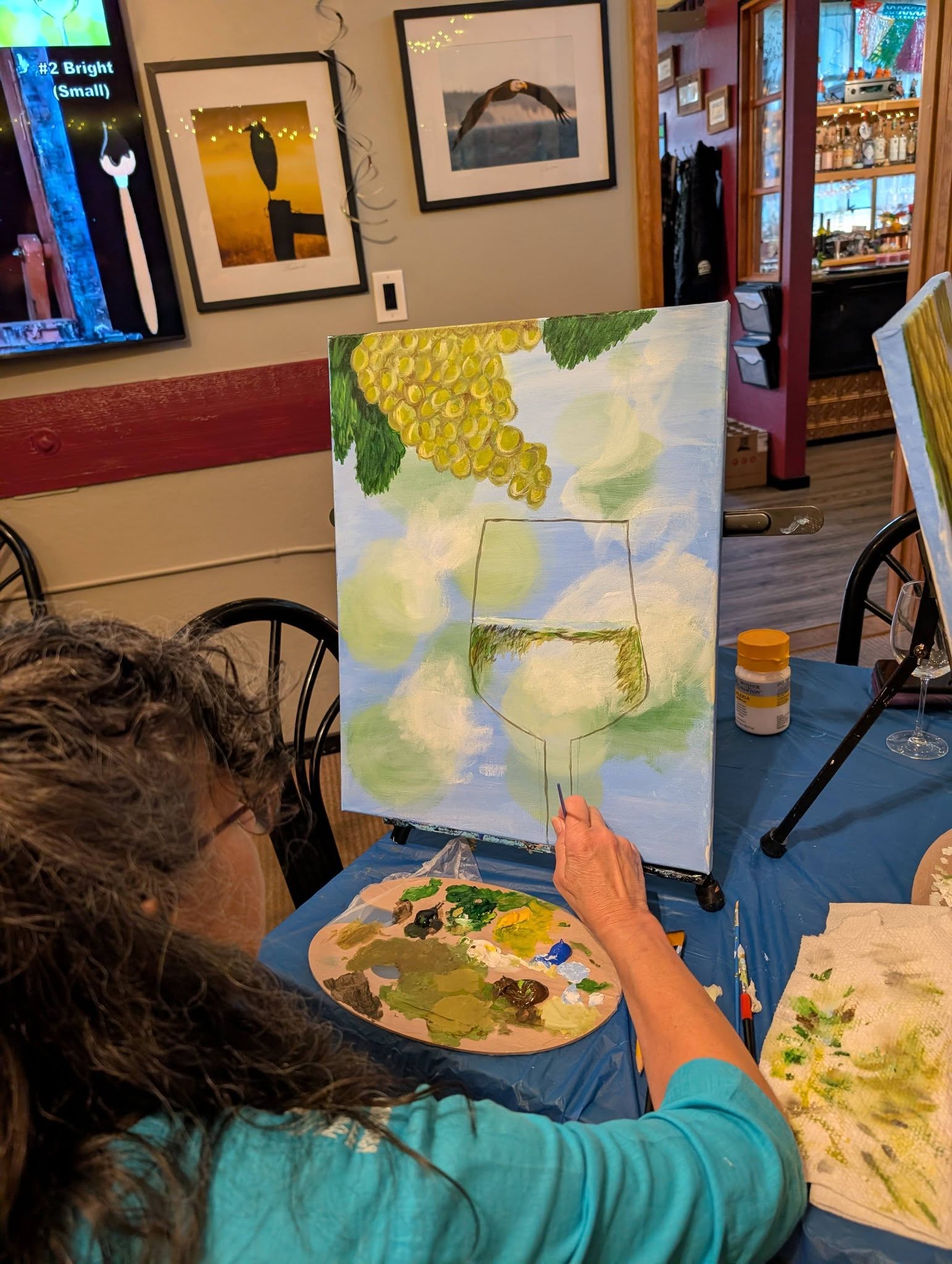 Guest painting a wine glass at a paint and sip class
